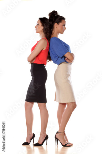 Two angry women leans backs on each other