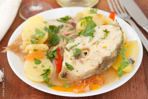 boiled fish with vegetables on white plate