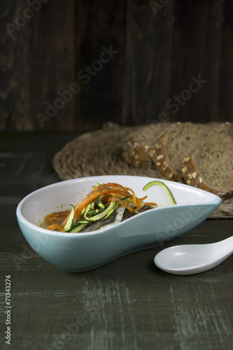 Hake and vegetable soup, on dark background