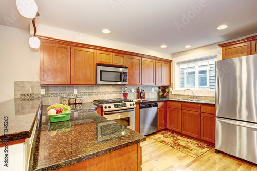 Maple kitchen cabinets with steel appliances and granite tops