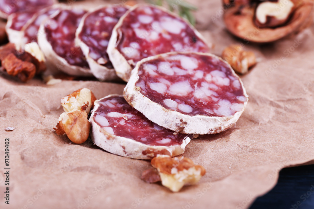 French salami and walnuts on craft paper background