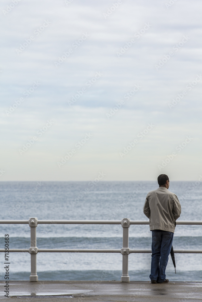Hombre con paraguas frente al mar