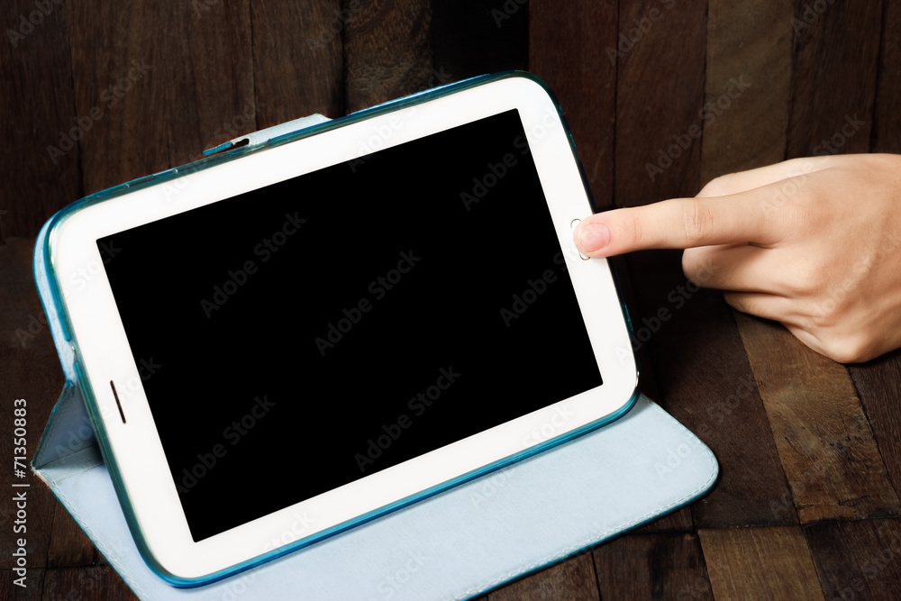 hand holding a tablet on wooden background hand holding a tablet on wooden background