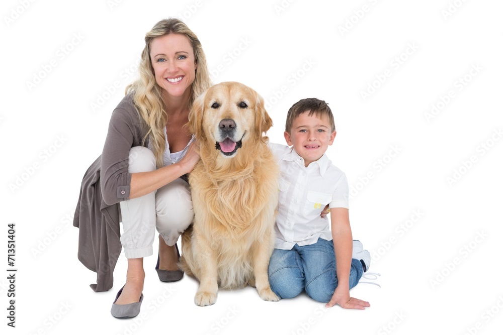 Smiling mother and son petting their golden retriever Smiling mother and son petting their golden retriever