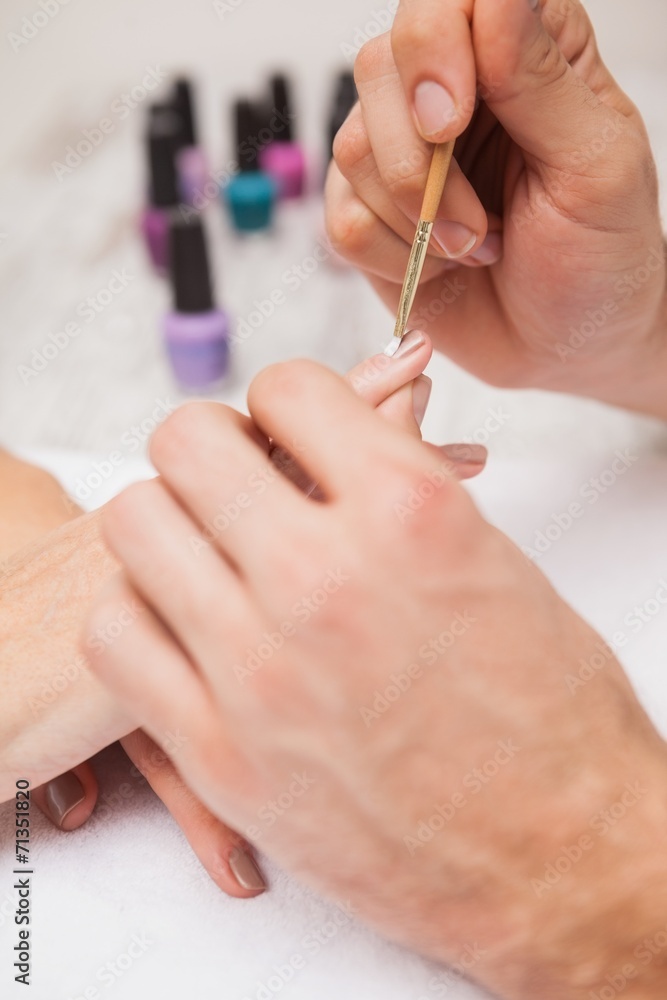 Manicurist cleaning a customers nails