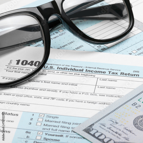 US Tax Form 1040 with dollars and glasses - 1 to 1 ratio