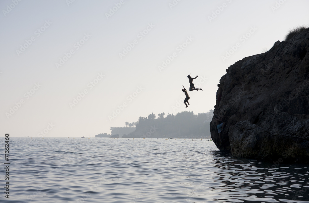 People jumping into the water from cliff - obrazy, fototapety, plakaty 
