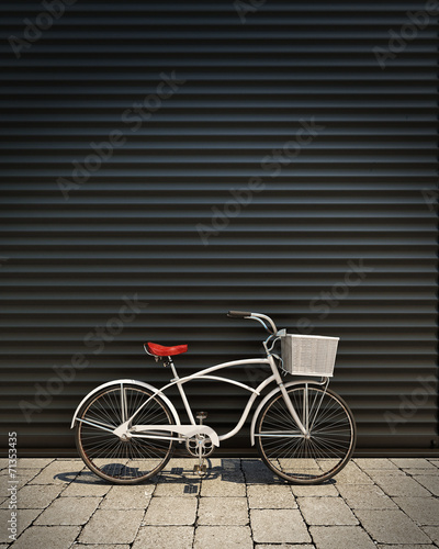 white retro bicycle in front of garage wall