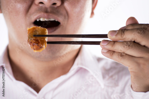Man with chopsticks eat egg springroll © kungverylucky