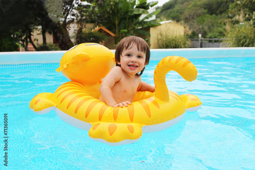 Happy 2 years boy sitting on inflatable toy in swimming pool Stock ...