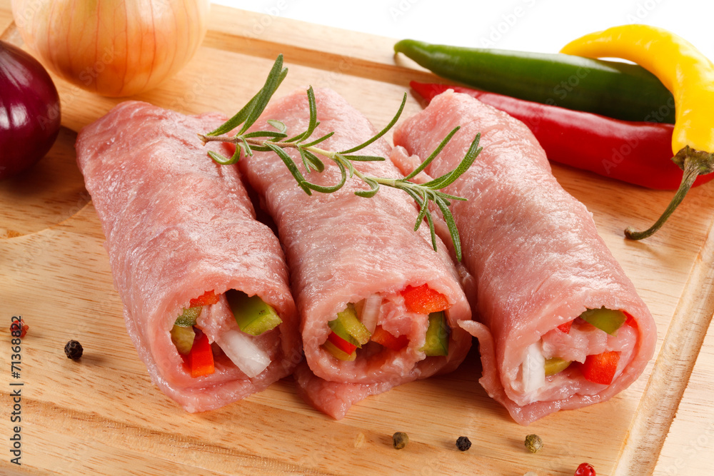 Raw pork chops on cutting board and vegetables Raw pork chops on cutting board and vegetables