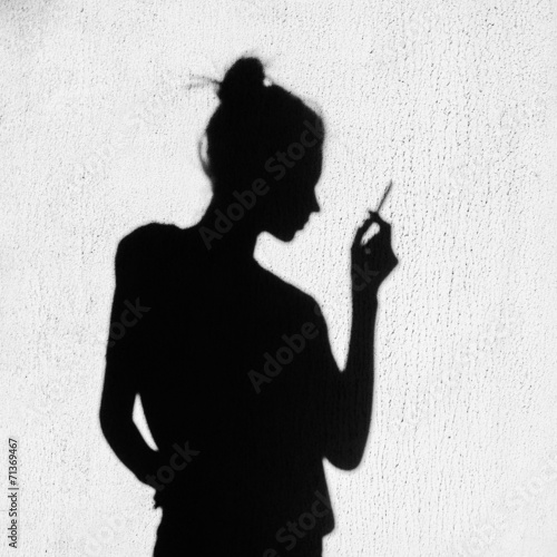  Shadow of sad girl smoking around on wall background photo