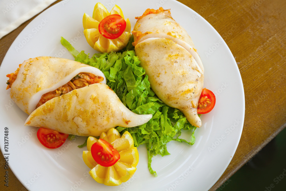 Squid stuffed with seafood in white plate, top view Squid stuffed with seafood in white plate, top view