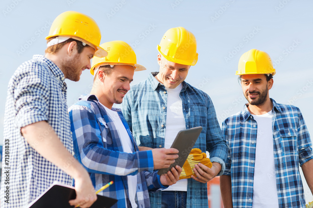 group of smiling builders with tablet pc outdoors group of smiling builders with tablet pc outdoors