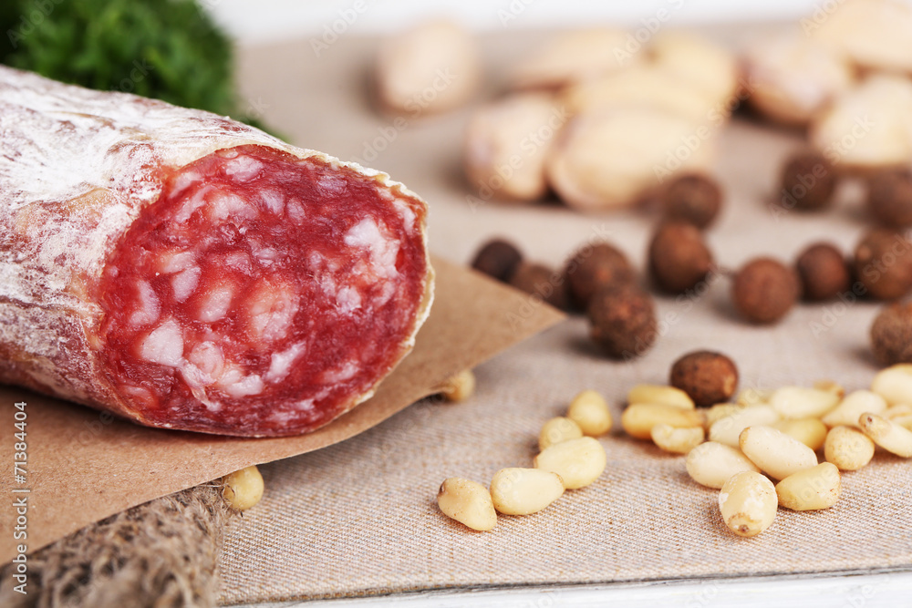 Italian salami on plate, on wooden background Italian salami on plate, on wooden background