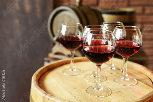 Glasses of wine in cellar with old barrels