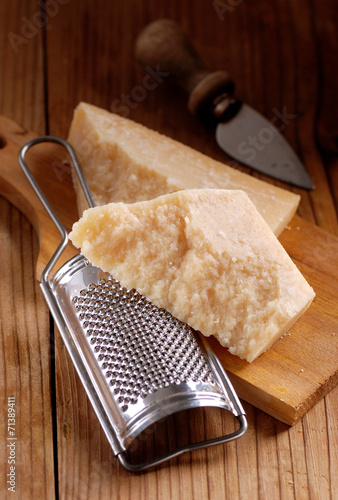 grattugia di acciaio e pezzo di formaggio parmigiano