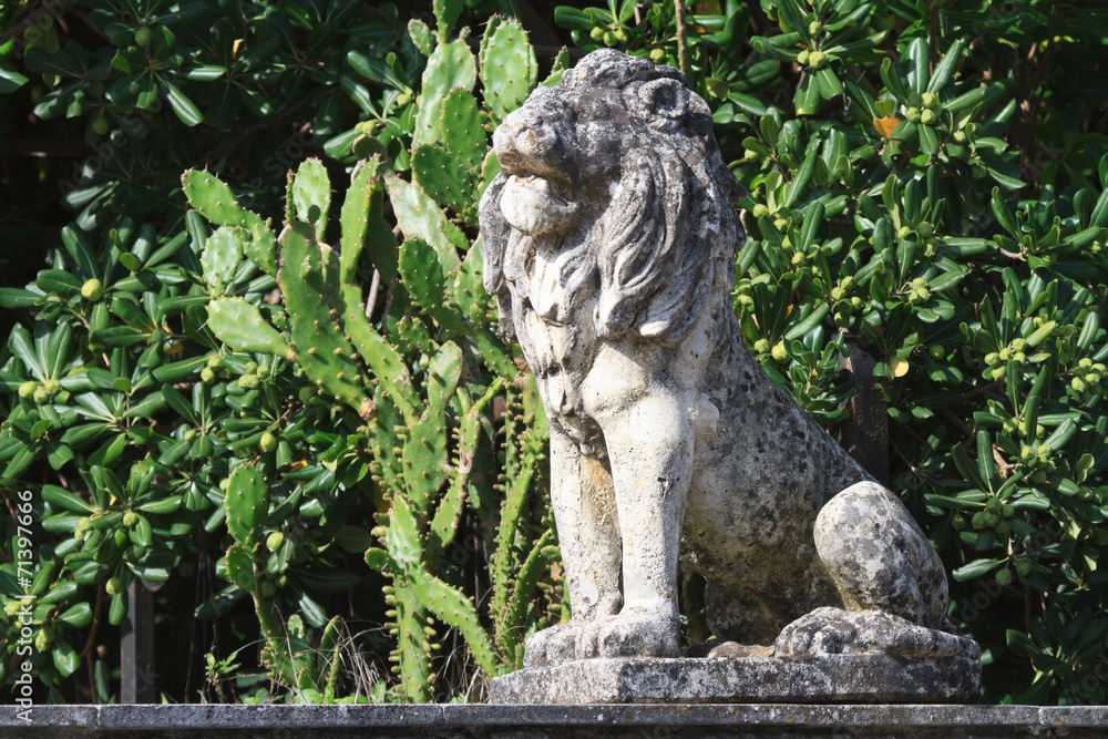 Old stone statue of a lion in the garden