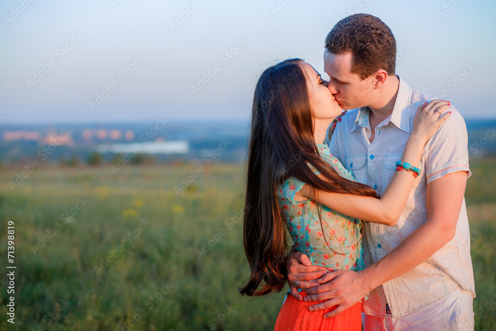 young beautiful couple on a cliff at sunset young beautiful couple on a cliff at sunset