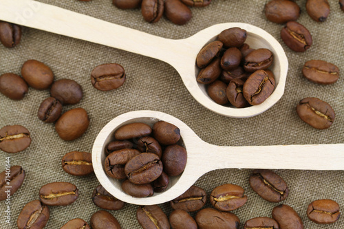 Coffee beans on wooden spoons, close up