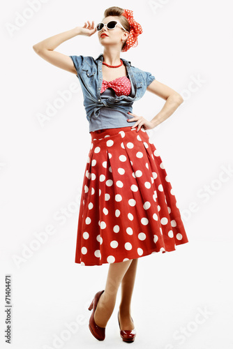 Pin-up young woman in vintage style trying on a sunglasses