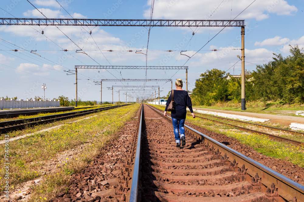 Naklejka premium Woman walking on railroad tracks