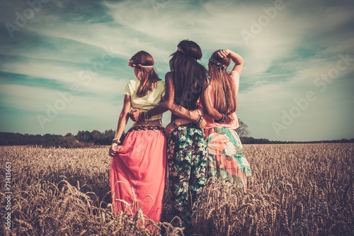 Multi-ethnic hippie girls  in a wheat field photo