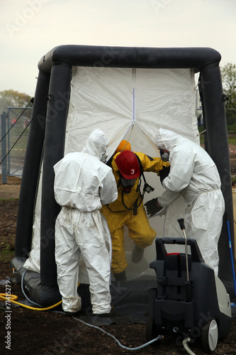 The person in chemical protection suit go out from danger zone photo