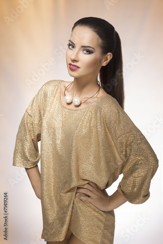 Young woman in spakling gold dress photo