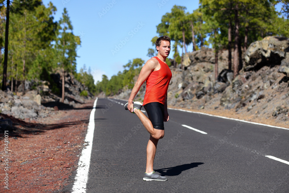 Runner man stretching thigh and legs