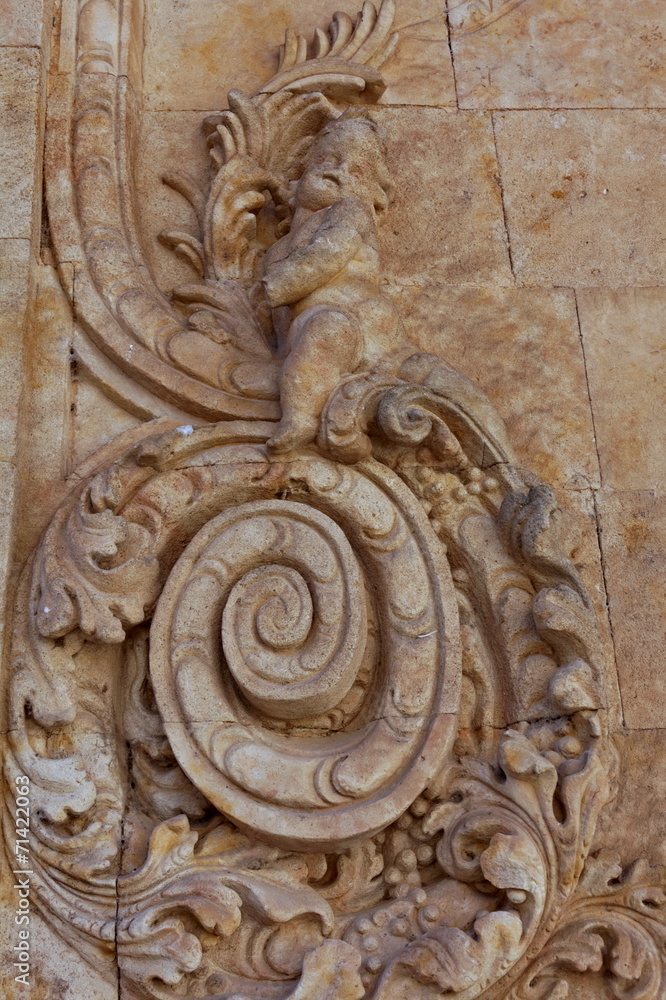 Ornement de pierre sculpté sur façade avec cupidon.