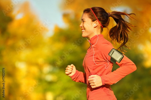 Woman runner running in fall autumn forest