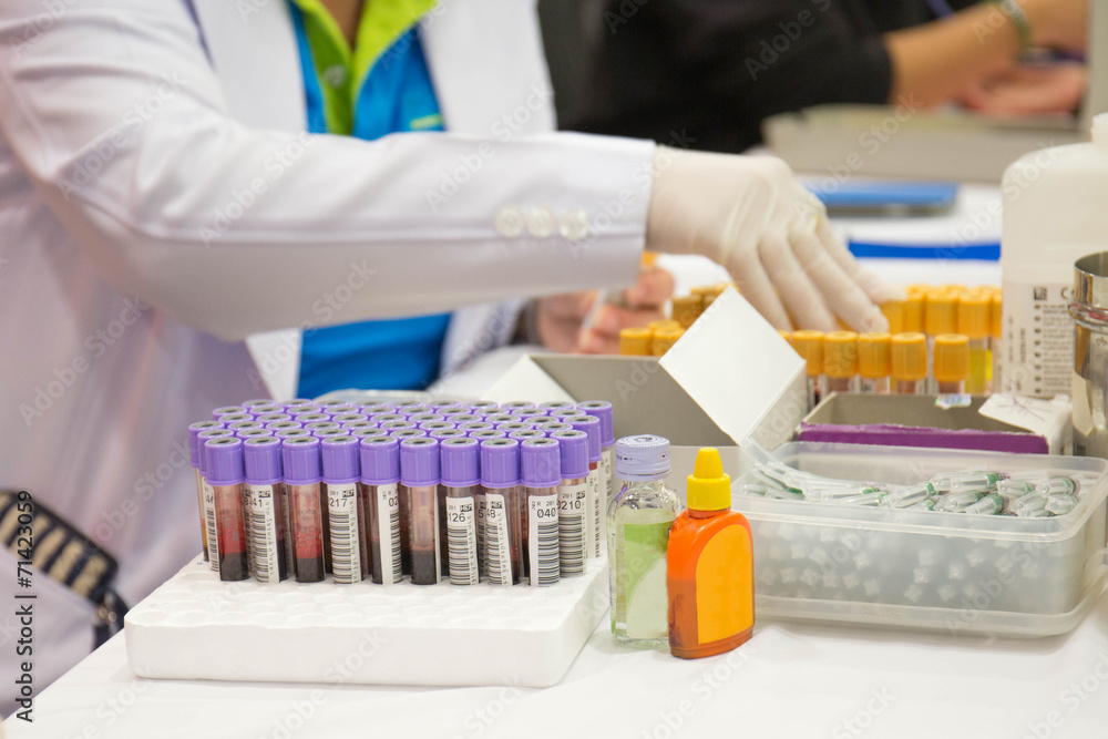 a nurse arranges test tubes with blood on a tray a nurse arranges test tubes with blood on a tray