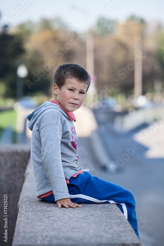 Small boy sitting on granite and looking at camera