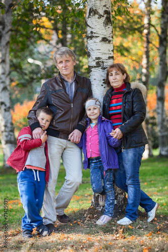 Four people family full length portrait in autumn park