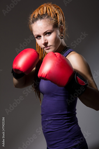 Beautiful girl with boxing gloves, dreadlocks. © kanzefar