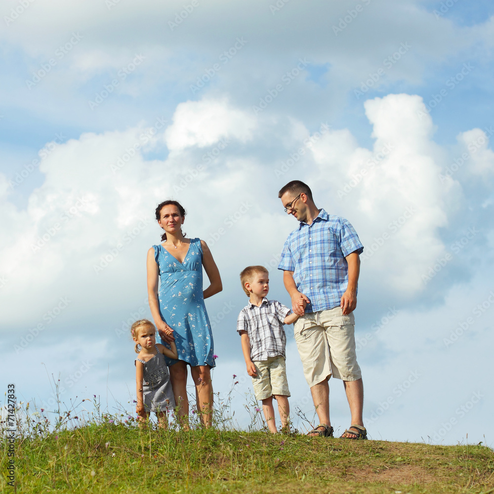 Fototapeta premium young happy family of four down from the mountains 
