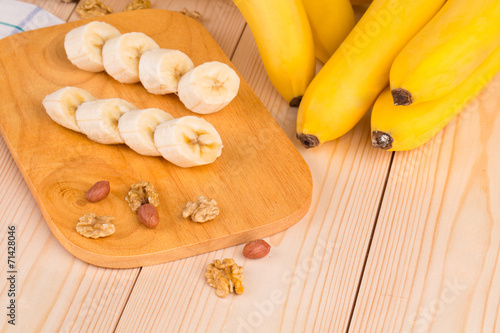 Banana slices on the wooden desk with nuts