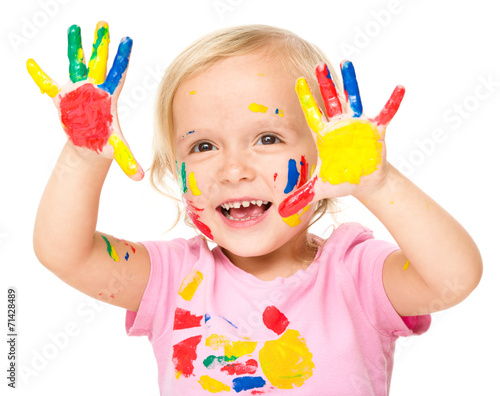 Portrait of a cute little girl playing with paints