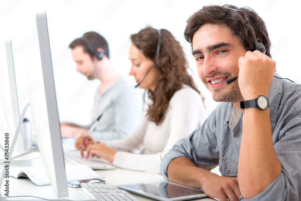 Fototapeta premium Young attractive man working in a call center