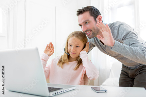 Father and his blond daughter using computer