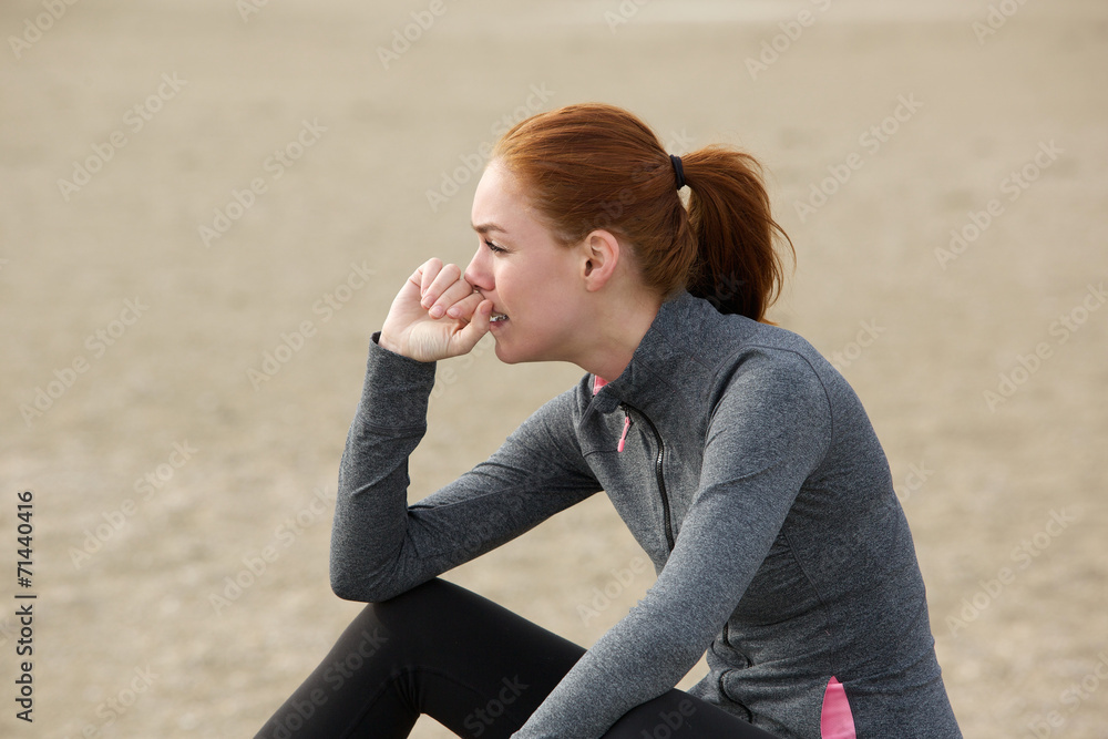Sporty woman sitting outdoors and relaxing after workout Sporty woman sitting outdoors and relaxing after workout