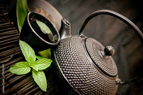 Black iron asian teapot with sprigs of mint