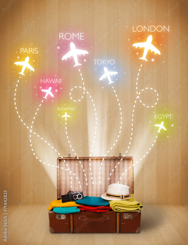 Travel bag with clothes and colorful planes flying out