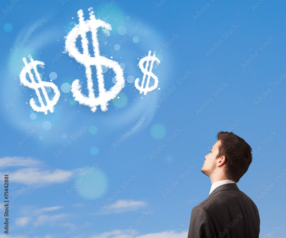 Businesman pointing at dollar sign clouds on blue sky Businesman pointing at dollar sign clouds on blue sky