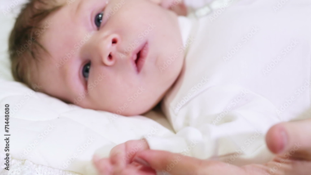 Lying baby holds hands her mother Lying baby holds hands her mother