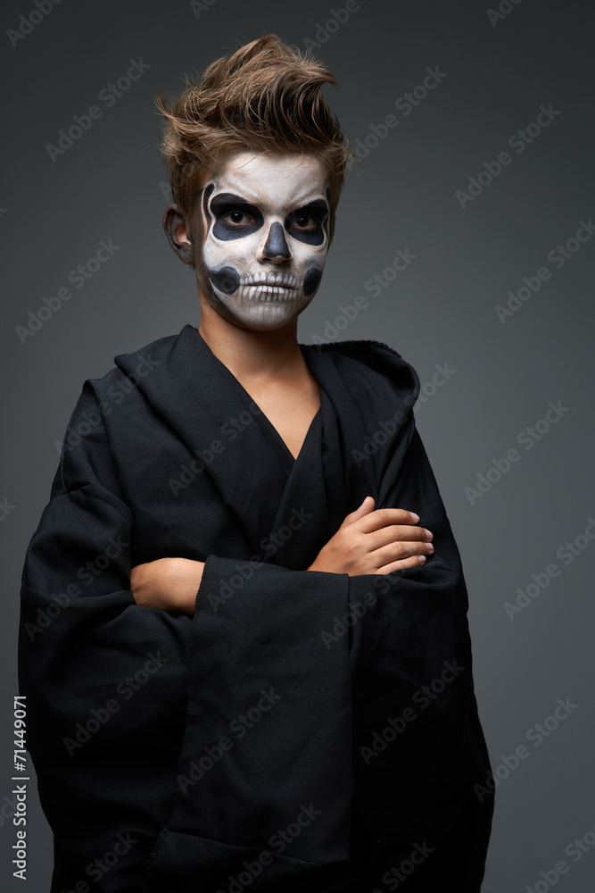 Teen with make-up of the skull in black cape Teen with make-up of the skull in black cape