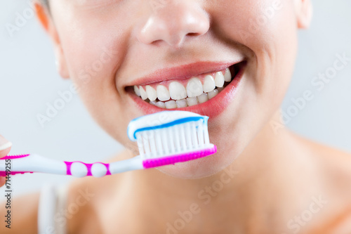 Beautiful young woman picking his teeth.