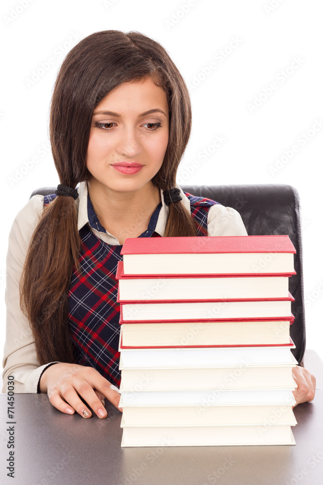 Portrait of a schoolgirl looking to a stack of books Portrait of a schoolgirl looking to a stack of books