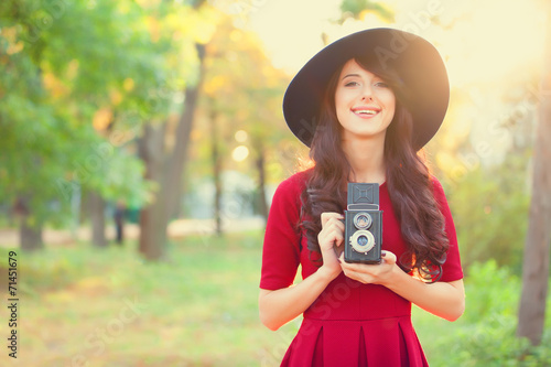 Brunette girl with camera in the park in sunset time photo